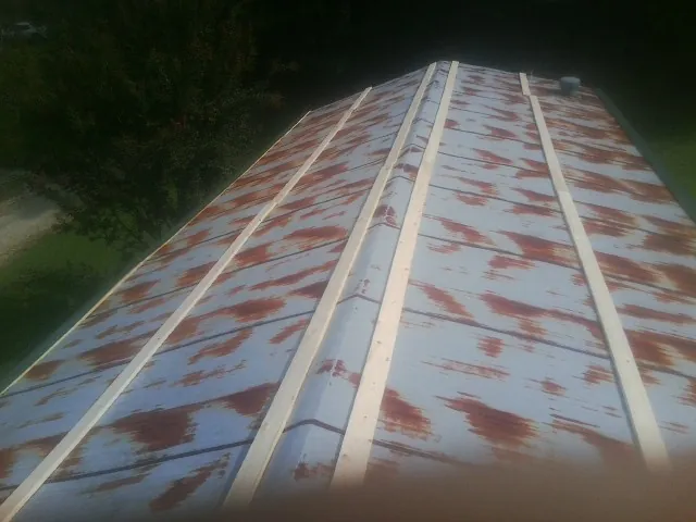 Rusted metal roof panels with new wood purlins before replacement — Storm Damage Roof Repair in Oakboro by Roofing Brothers