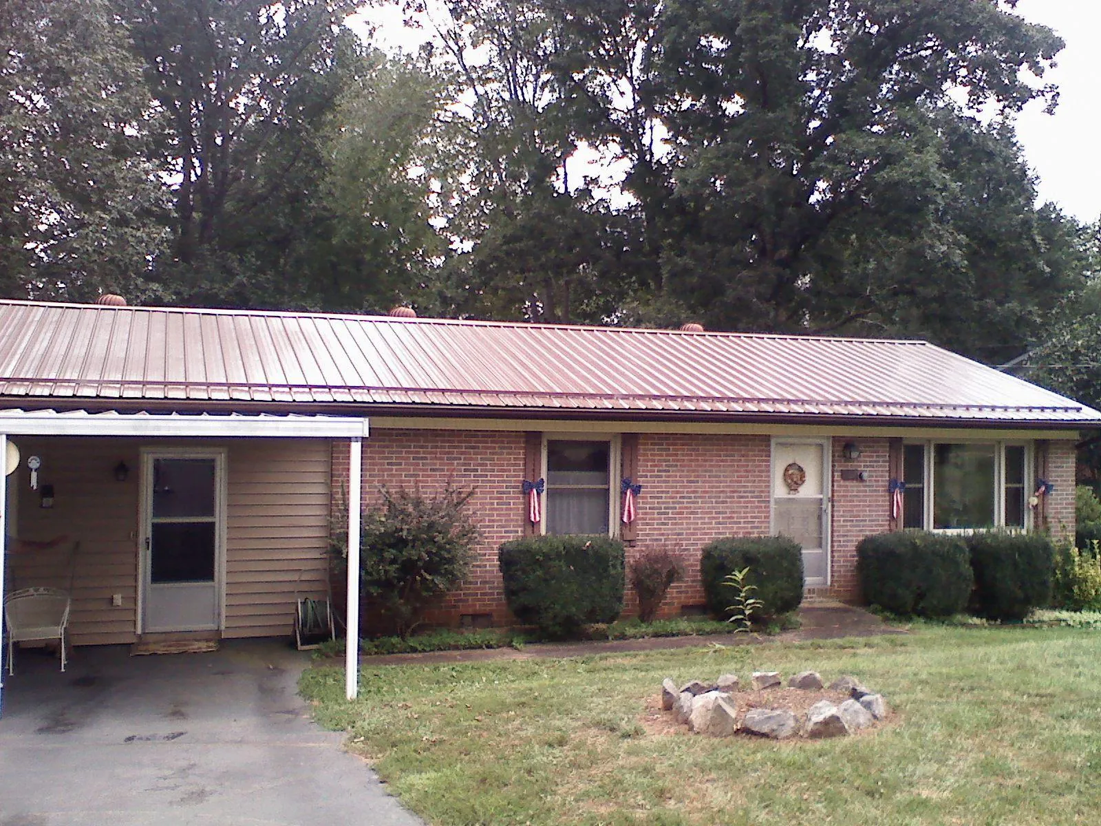Bronze metal roof and carport on a brick ranch home — Roof Repair work by our crew in Oakboro